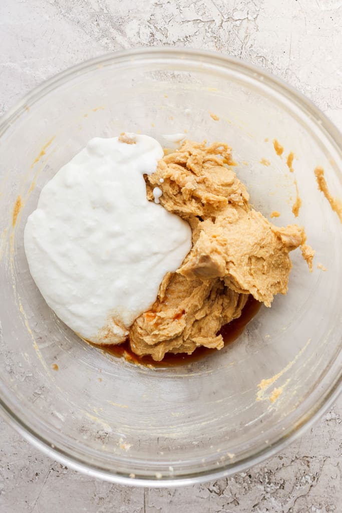 The ingredients for peanut butter cookie dough in a glass bowl.