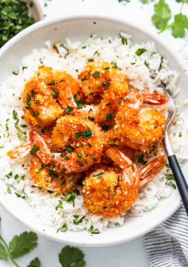 A bowl of rice with shrimp on top.