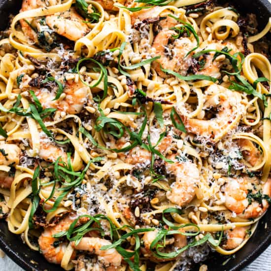 A skillet filled with pasta and shrimp.