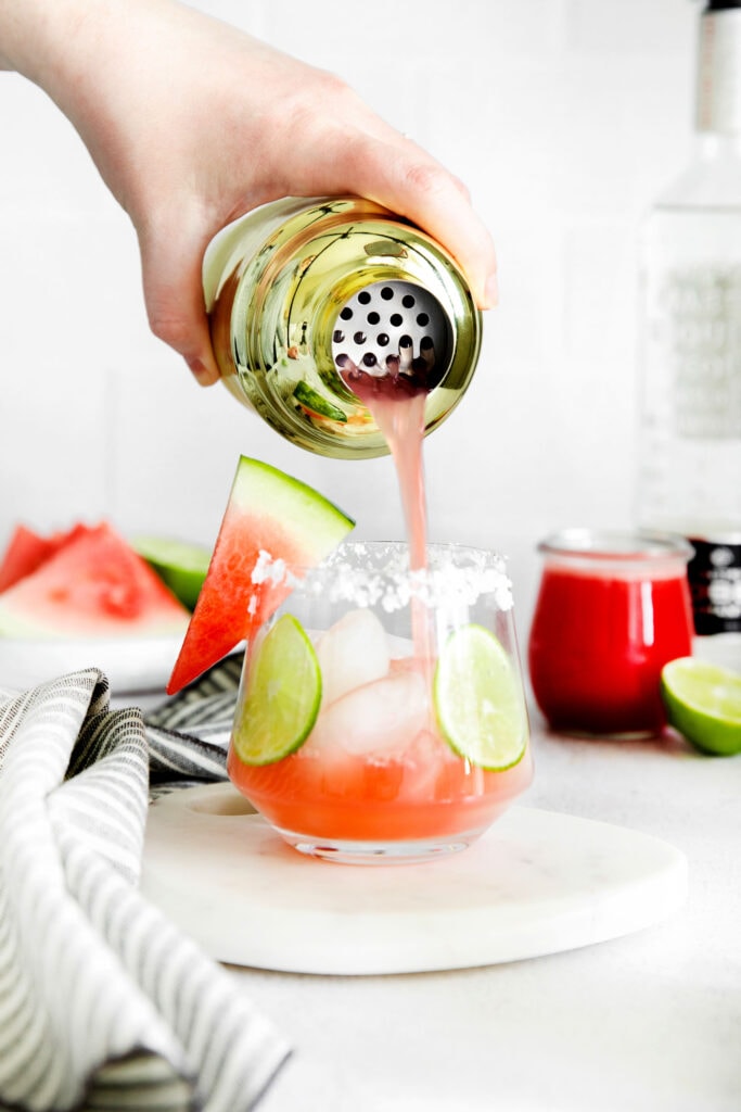 Pouring the watermelon margarita on the rocks. 